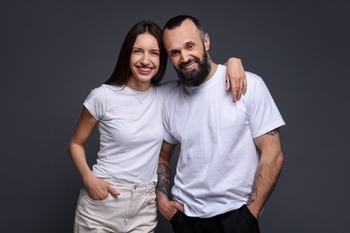 Photo of Portrait of happy daughter and father on dark grey background