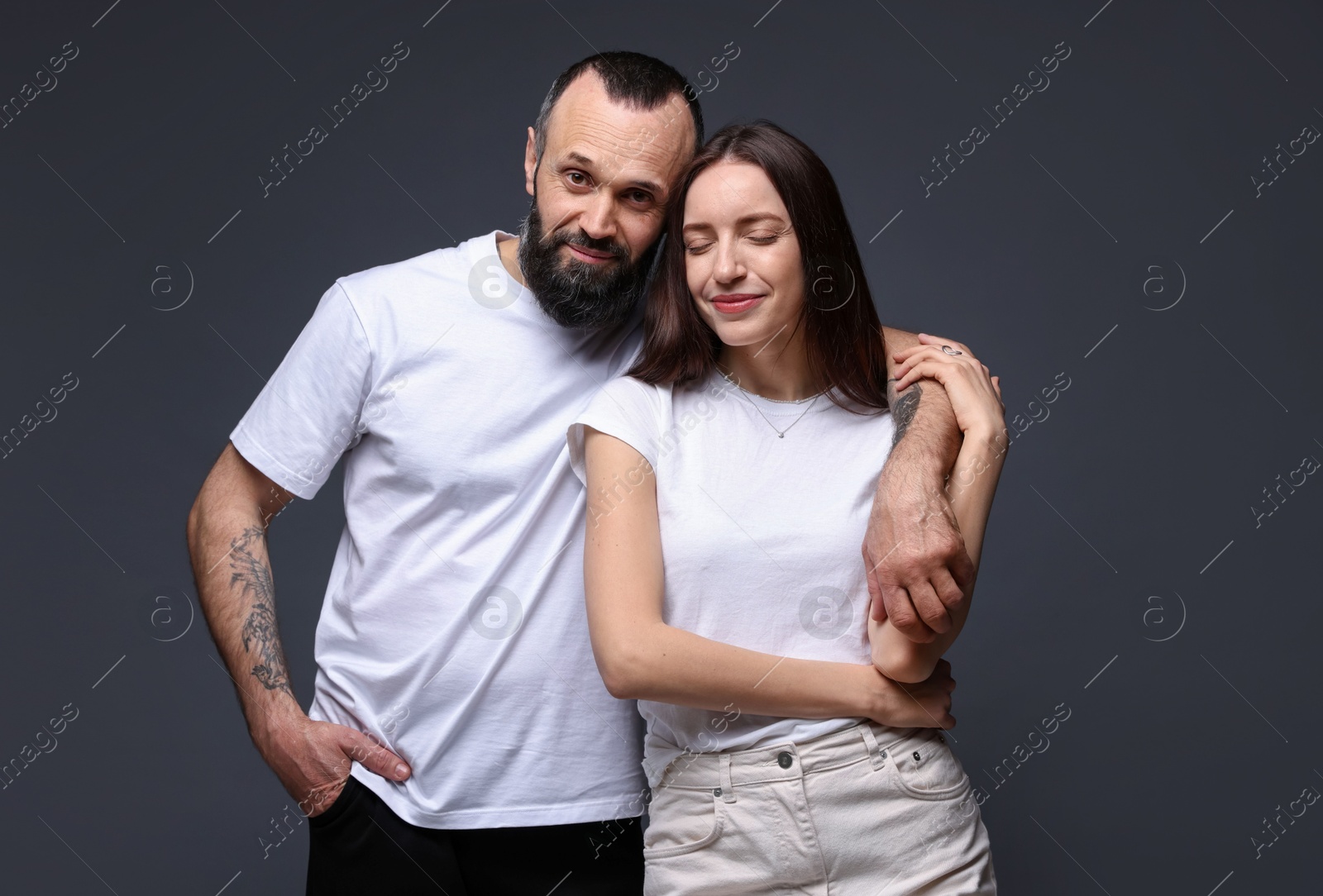 Photo of Portrait of happy daughter and father on dark grey background