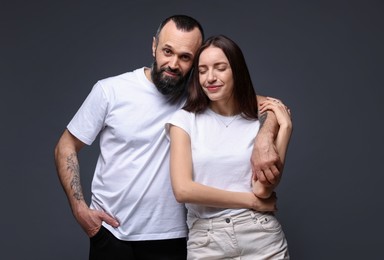 Photo of Portrait of happy daughter and father on dark grey background