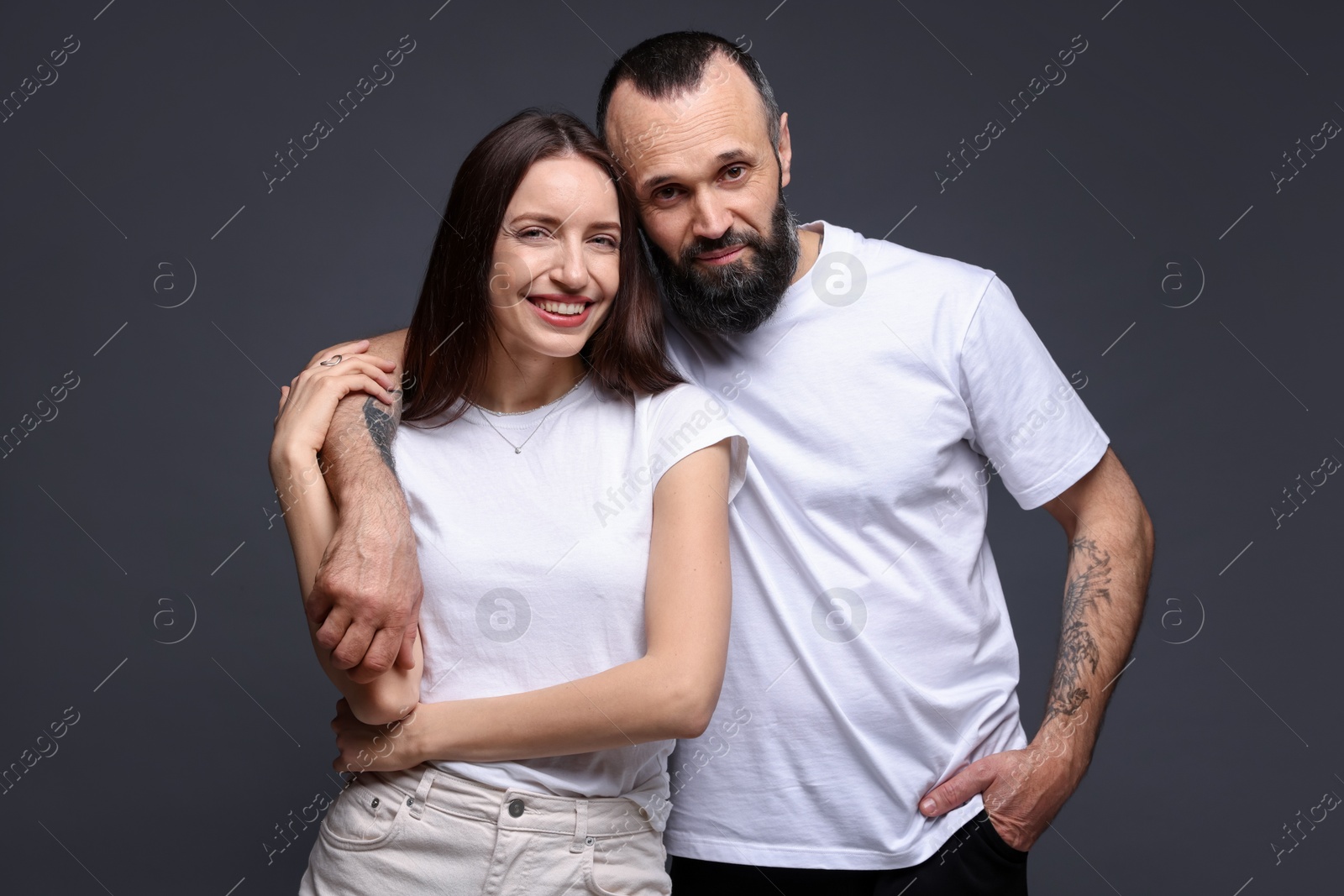 Photo of Portrait of happy daughter and father on dark grey background