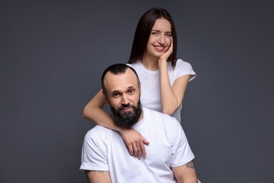 Photo of Portrait of happy daughter and father on dark grey background