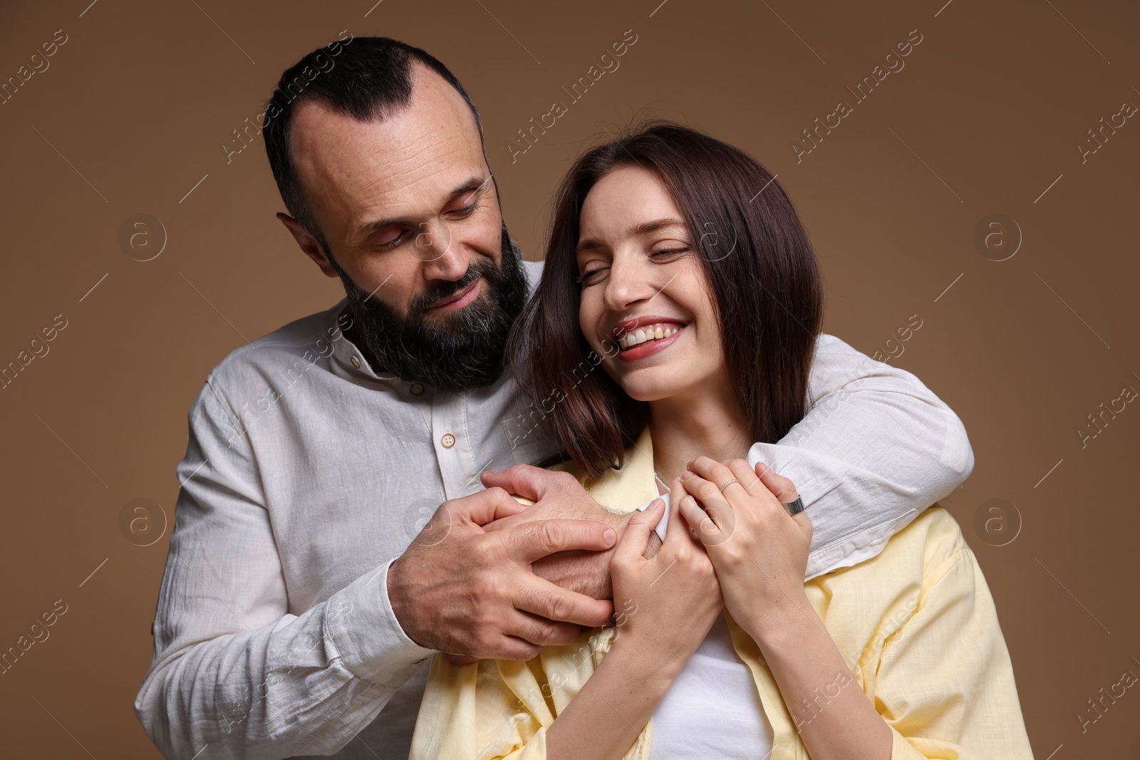 Photo of Happy daughter and father on brown background