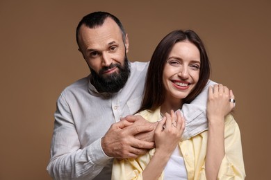 Photo of Portrait of happy daughter and father on brown background