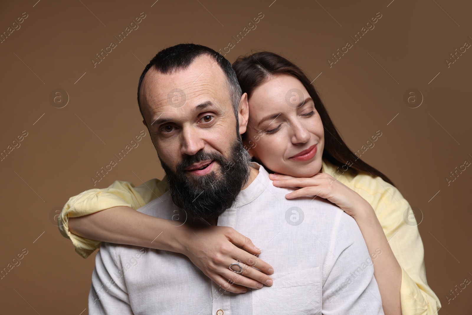 Photo of Portrait of happy daughter and father on brown background