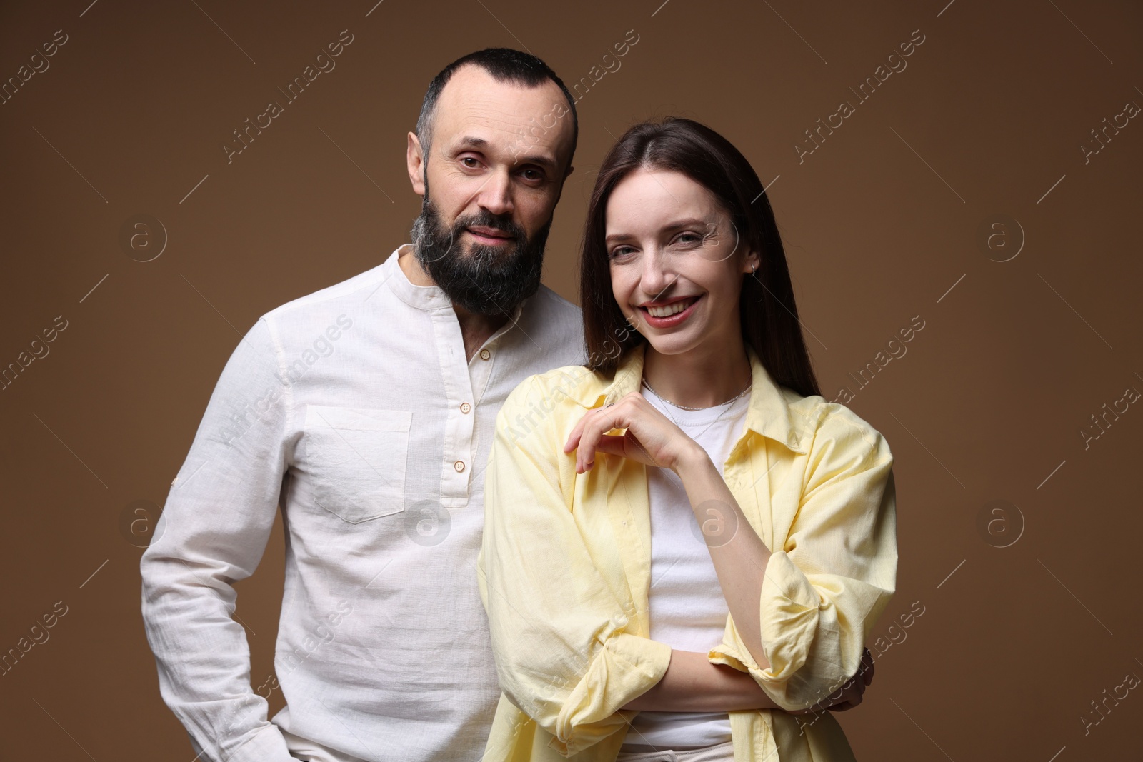 Photo of Portrait of happy daughter and father on brown background