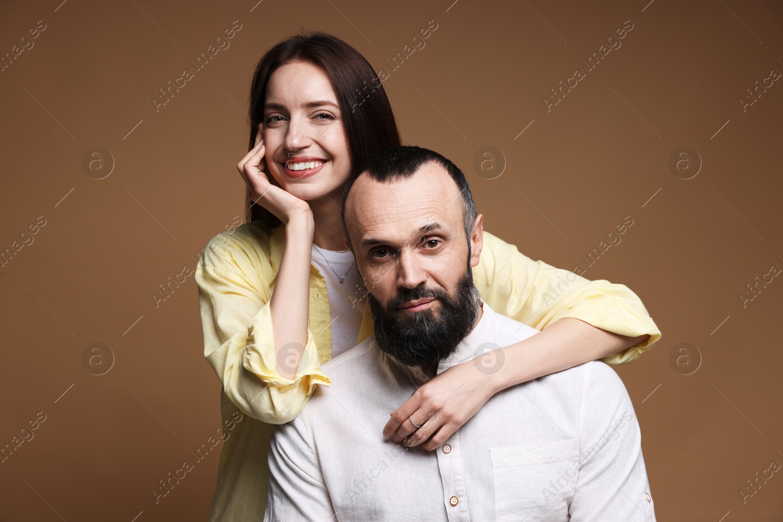 Photo of Portrait of happy daughter and father on brown background