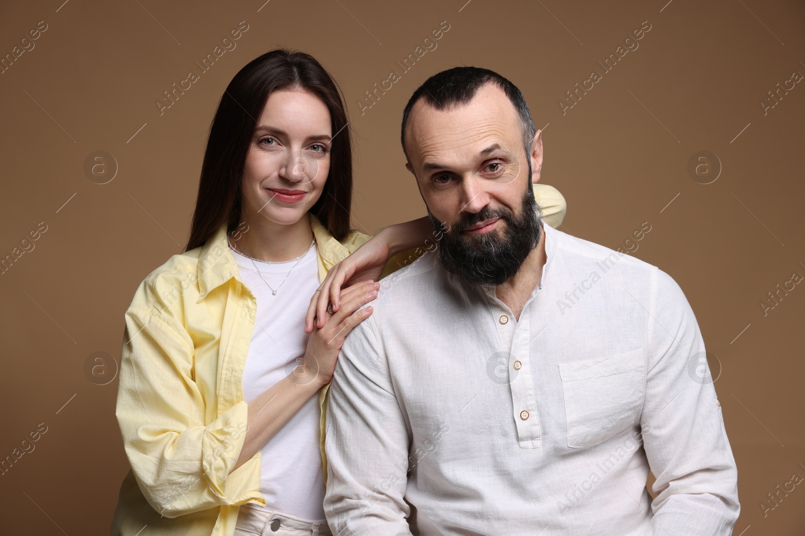 Photo of Portrait of happy daughter and father on brown background