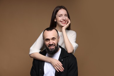 Photo of Portrait of happy daughter and father on brown background