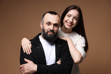 Photo of Portrait of happy daughter and father on brown background