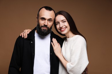 Photo of Portrait of happy daughter and father on brown background