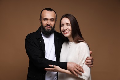 Photo of Portrait of happy daughter and father on brown background