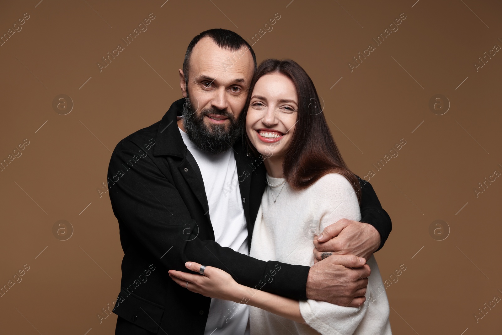 Photo of Portrait of happy daughter and father on brown background