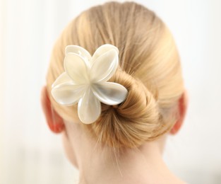 Photo of Woman with beautiful hair clip on blurred background, back view