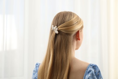 Photo of Woman with beautiful hair clip indoors, back view