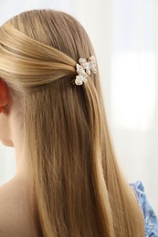 Photo of Woman with beautiful hair clip indoors, closeup