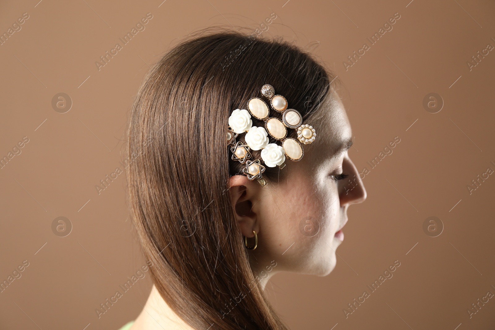 Photo of Woman with beautiful hair clips on brown background