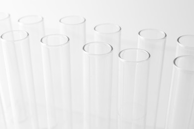 Photo of Empty test tubes on light background, closeup. Laboratory glassware