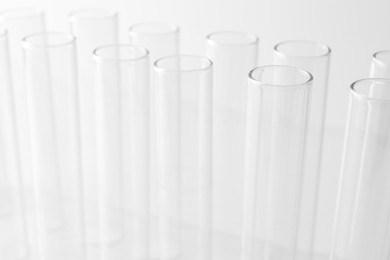 Photo of Empty test tubes on light background, closeup. Laboratory glassware