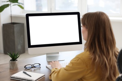 Photo of Woman working on computer at wooden desk in office. Mockup for design