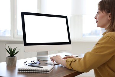 Photo of Woman working on computer at wooden desk in office. Mockup for design