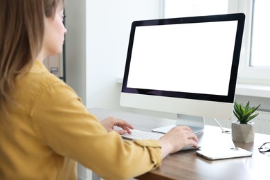 Photo of Woman working on computer at wooden desk in office. Mockup for design