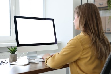 Photo of Woman working on computer at wooden desk in office. Mockup for design