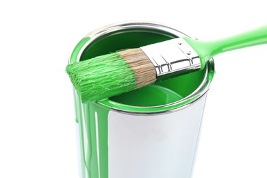 Photo of Can of light green paint and brush isolated on white