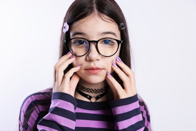 Photo of Teenage girl in stylish clothes and glasses posing on white background. Makeup in anime style