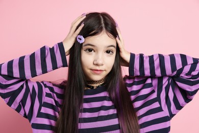 Photo of Teenage girl in stylish clothes posing on pink background. Makeup in anime style