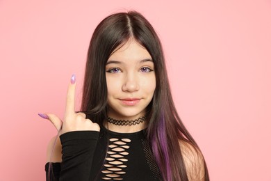 Photo of Teenage girl posing on pink background. Makeup and clothes in anime style