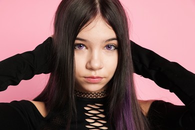 Photo of Teenage girl posing on pink background. Makeup and clothes in anime style