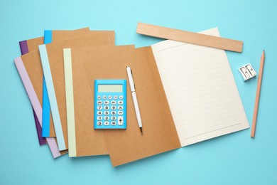 Photo of Copybooks and other different stationery on light blue background, flat lay