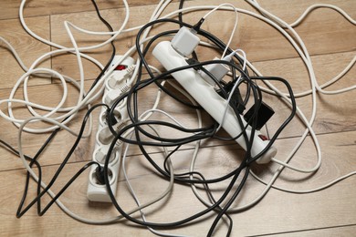 Photo of Extension power boards overloaded with plugs on wooden floor