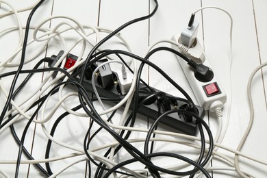 Photo of Extension power boards overloaded with plugs on wooden floor