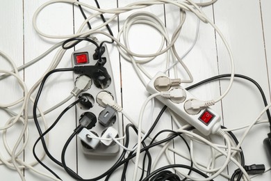 Photo of Extension power boards overloaded with plugs on wooden floor