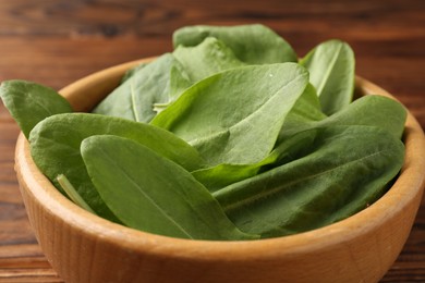 Photo of Fresh green sorrel leaves in bowl on table, closeup