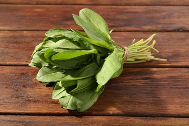 Photo of Bunch of fresh green sorrel leaves on wooden table, closeup