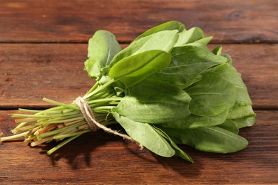 Photo of Bunch of fresh green sorrel leaves on wooden table, closeup