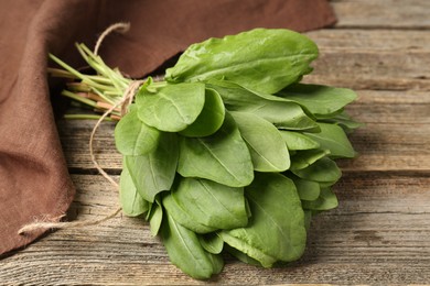 Photo of Bunch of fresh green sorrel leaves on wooden table, closeup