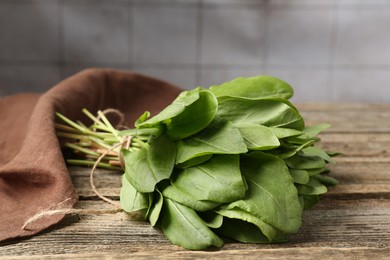 Photo of Bunch of fresh green sorrel leaves on wooden table, closeup