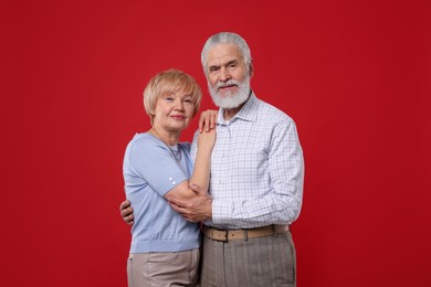 Photo of Portrait of lovely senior couple on red background