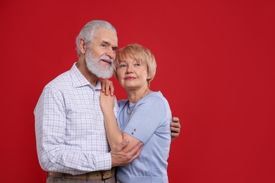 Photo of Lovely senior couple on red background. Space for text