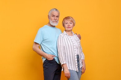 Photo of Portrait of lovely senior couple on orange background