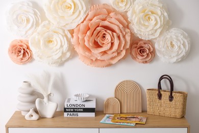 Photo of Beautiful decorative paper flowers on wall in room