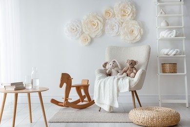 Photo of Beautiful decorative paper flowers on white wall in child's room