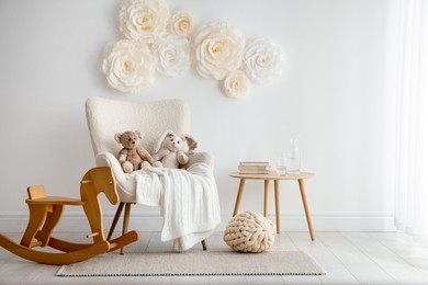 Photo of Beautiful decorative paper flowers on white wall in child's room