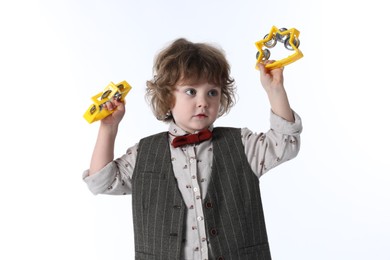 Photo of Cute little boy playing toy tambourines on white background