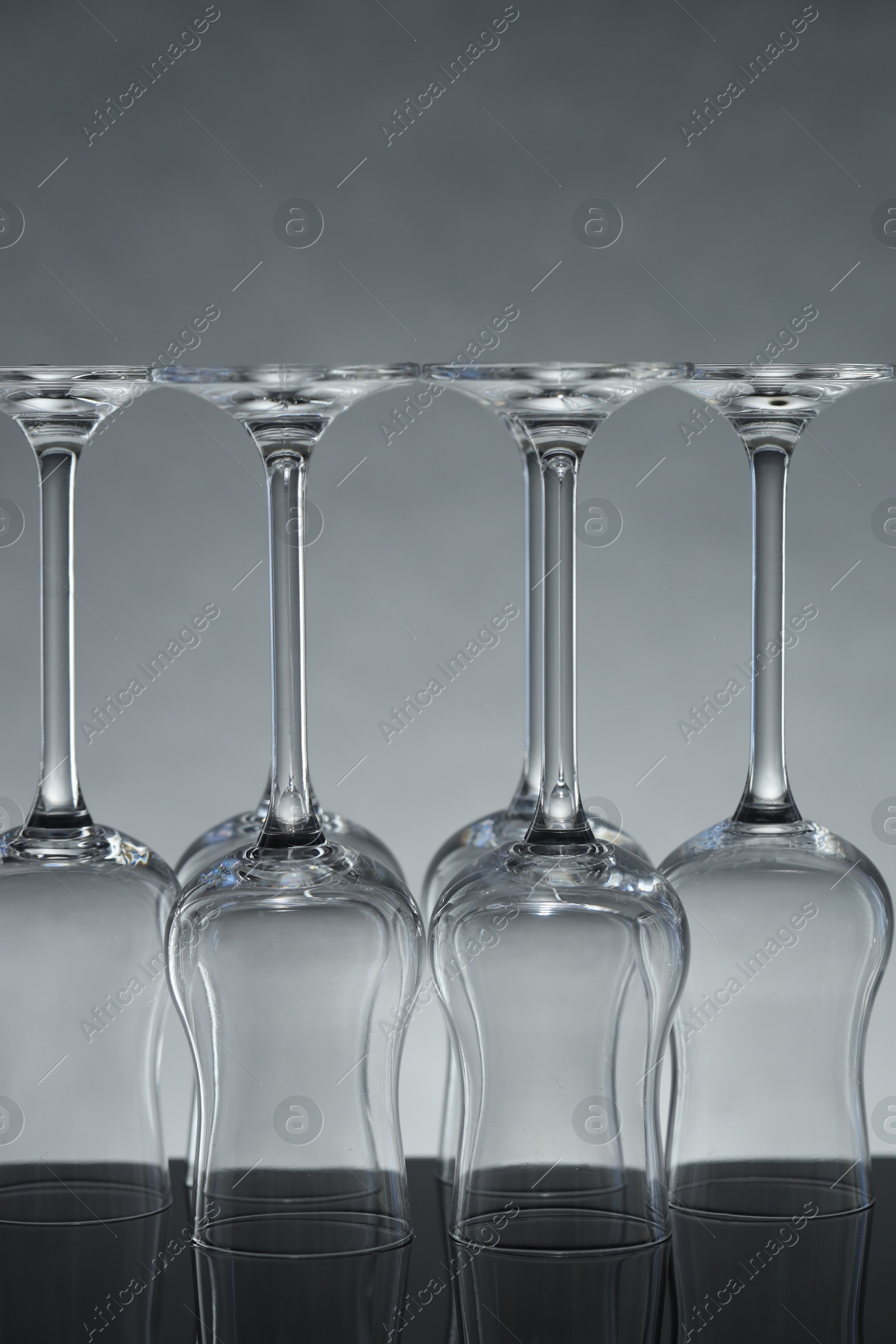 Many clean glass on mirror surface against light background Photo of Many clean glass on mirror surface against light background