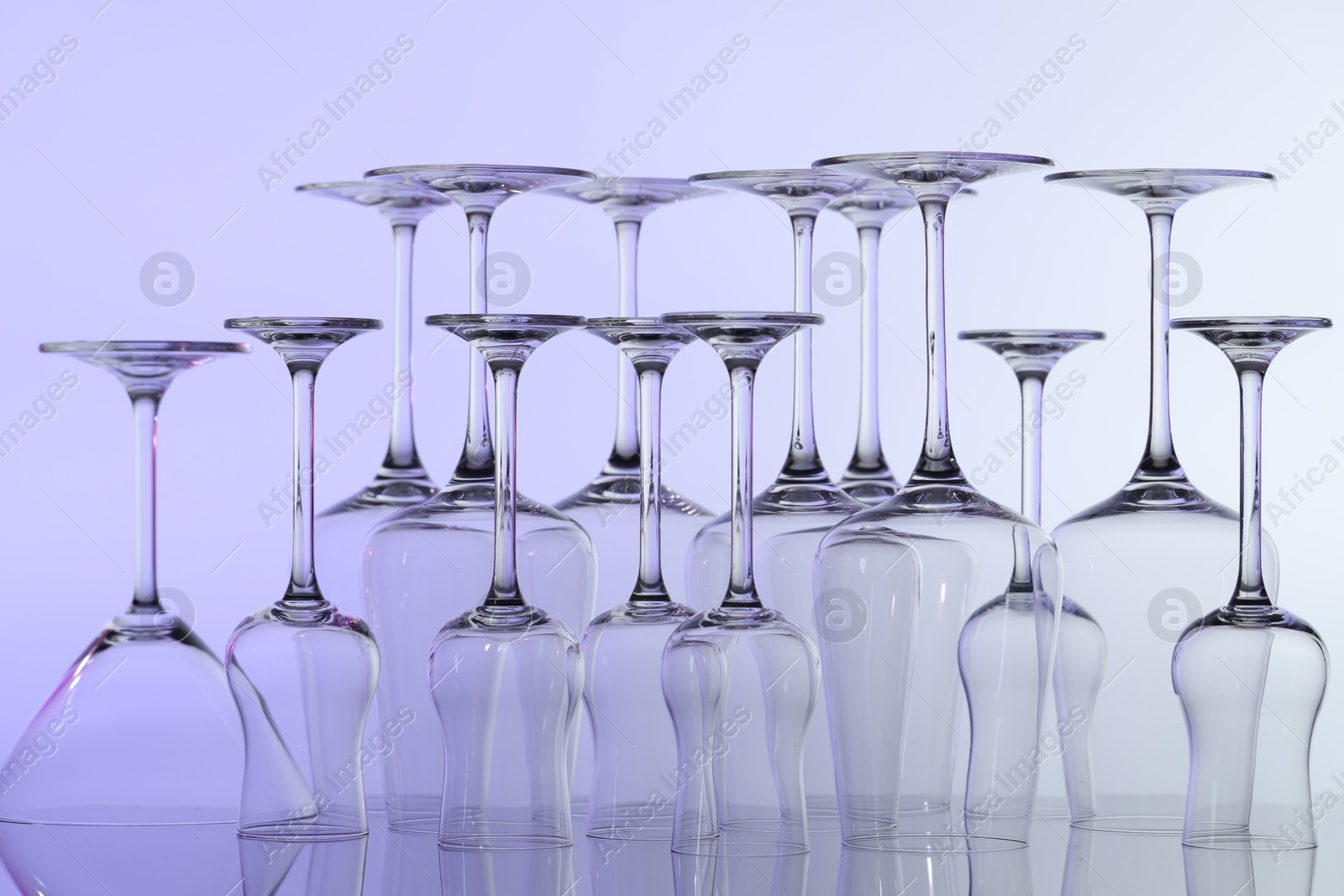 Many clean glass on mirror surface against light background Photo of Many clean glass on mirror surface against light background