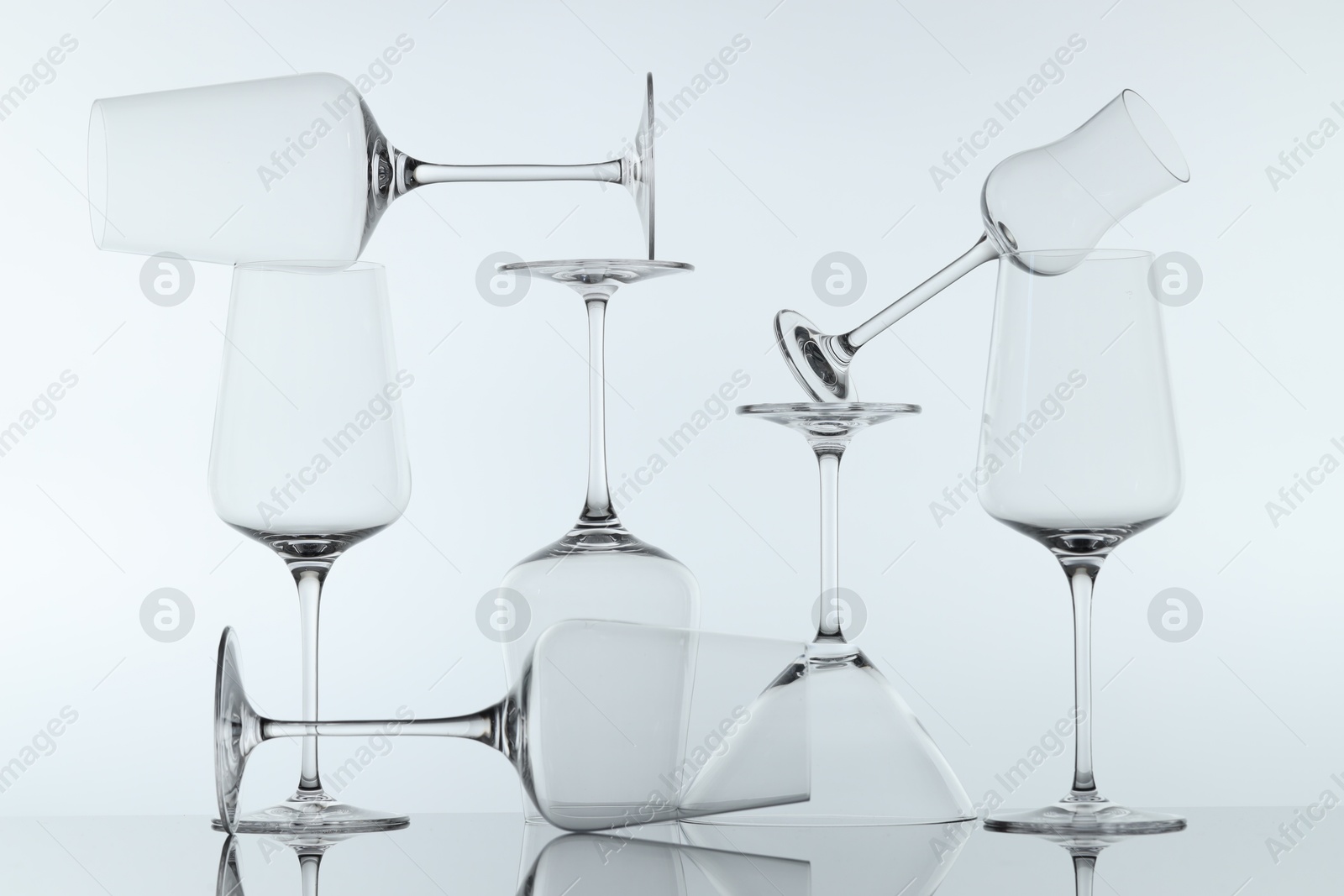 Many clean glass on mirror surface against light background Photo of Many clean glass on mirror surface against light background